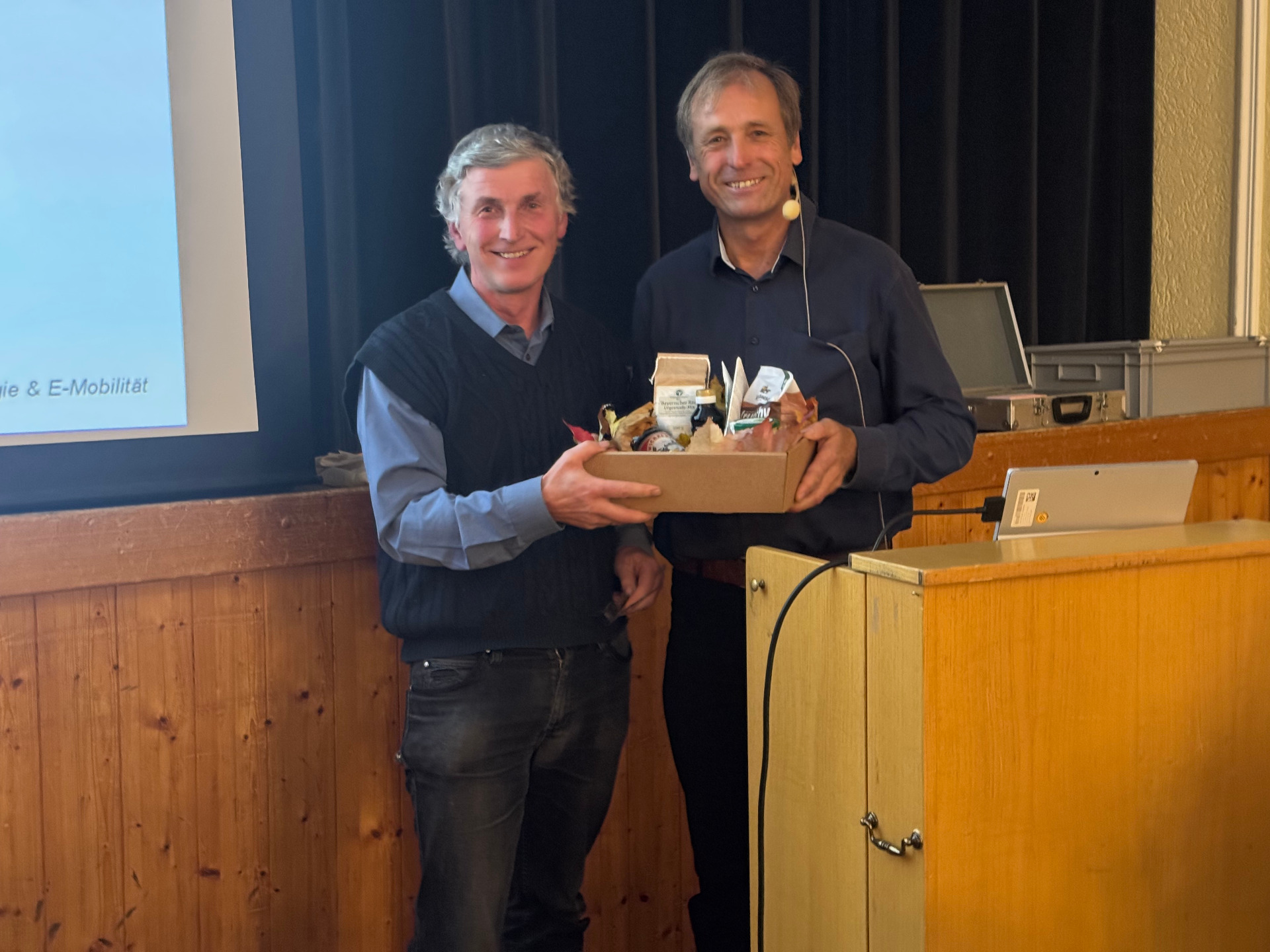 Aktionsbündnis-Sprecher Georg Huber (links) überreicht Hans Urban (rechts) eine Genusskiste der Ökomodellregion Rupertiwinkel